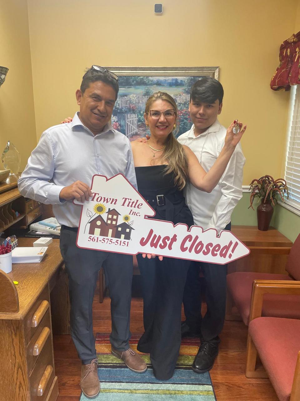 Familia celebrando con cartel Just Closed después del cierre