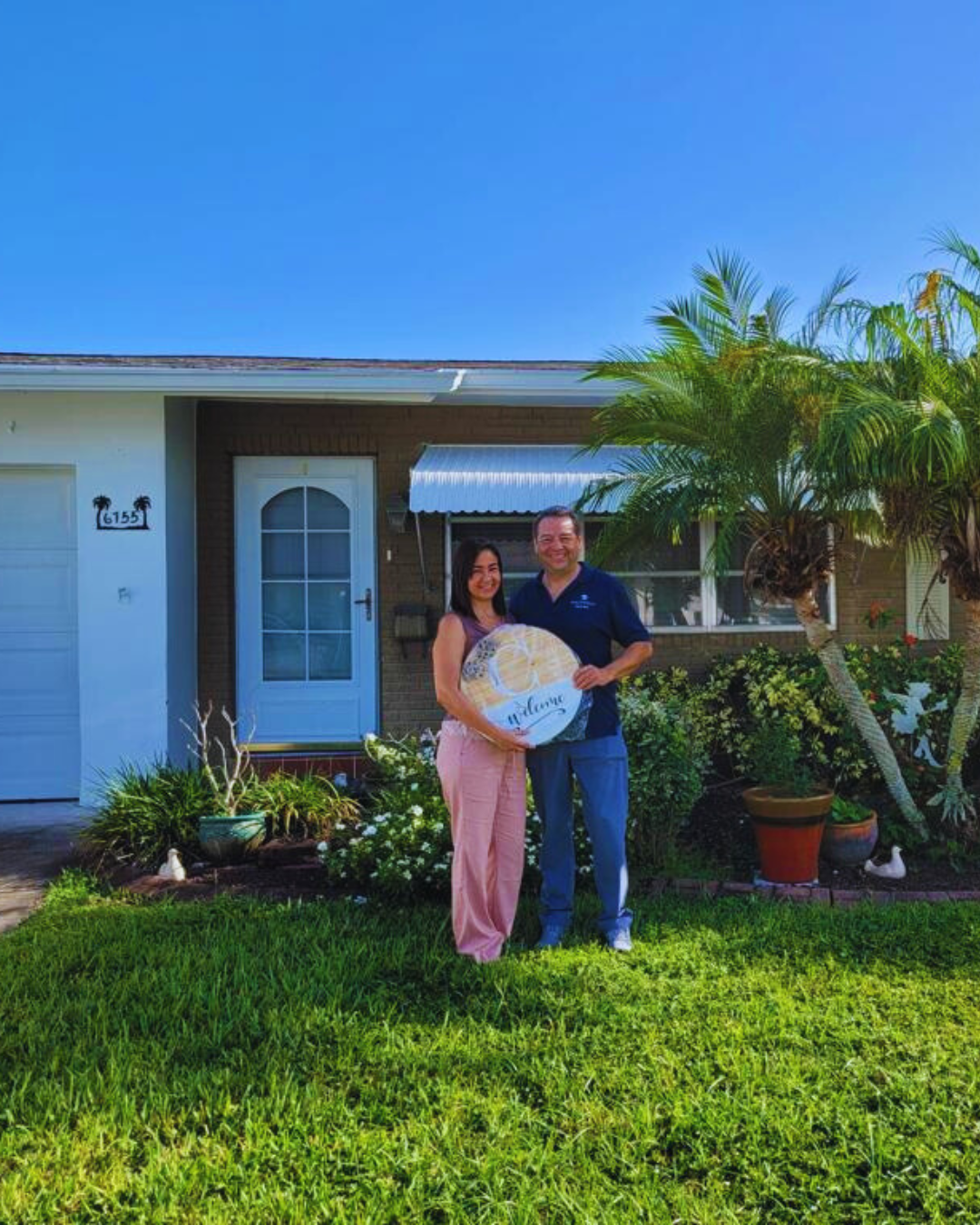 Pareja celebrando frente a su nueva casa en Florida