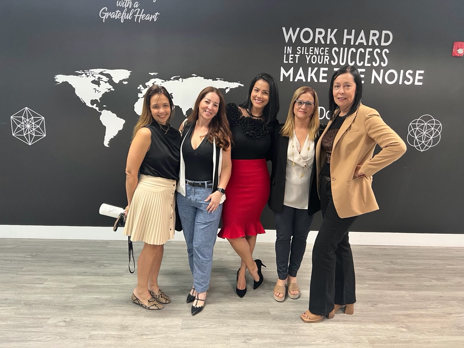 Juliana con asistentes frente al mural del mapa mundial Work Hard