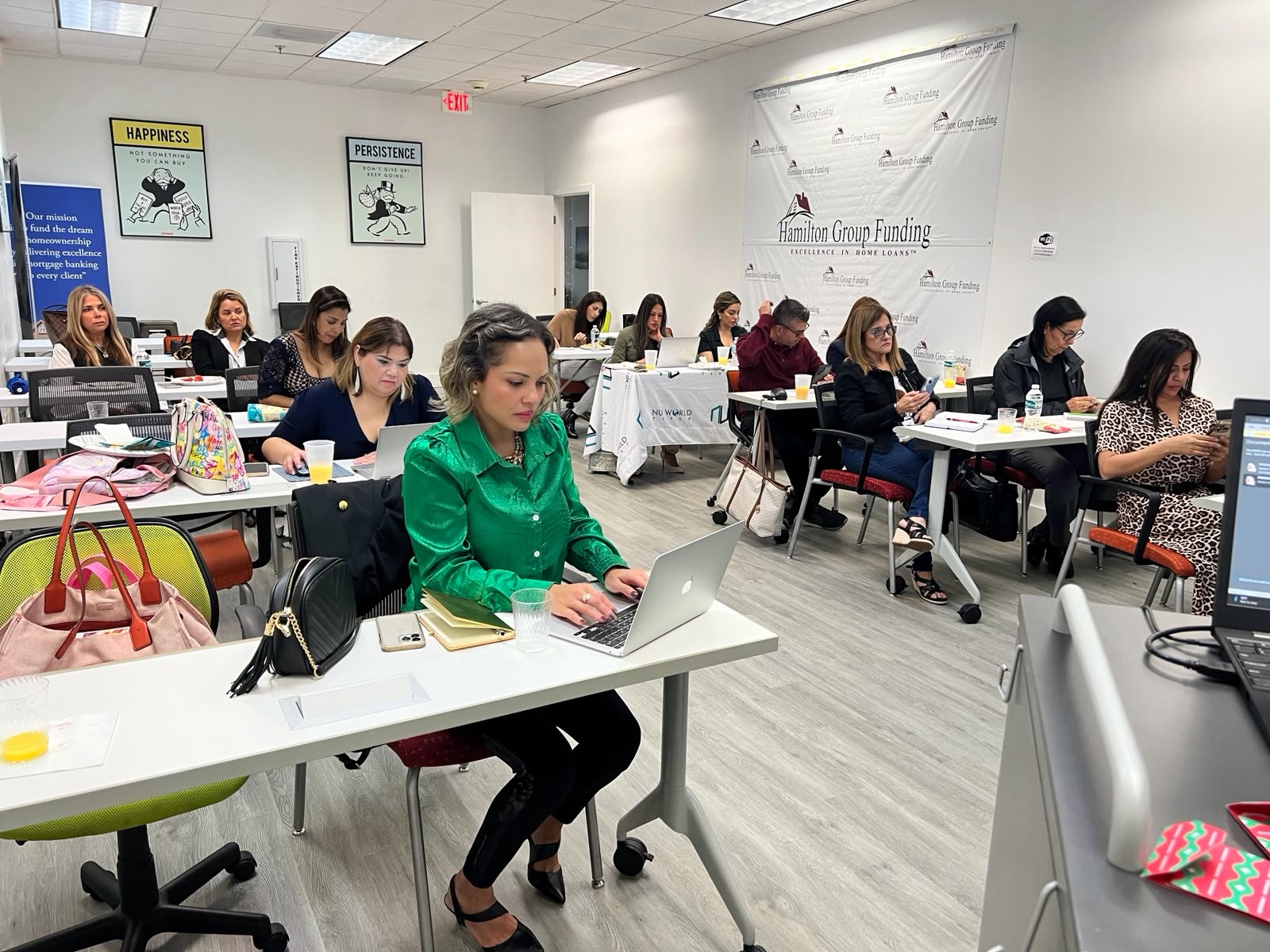 Asistentes trabajando con laptops durante un seminario en Hamilton Group Funding