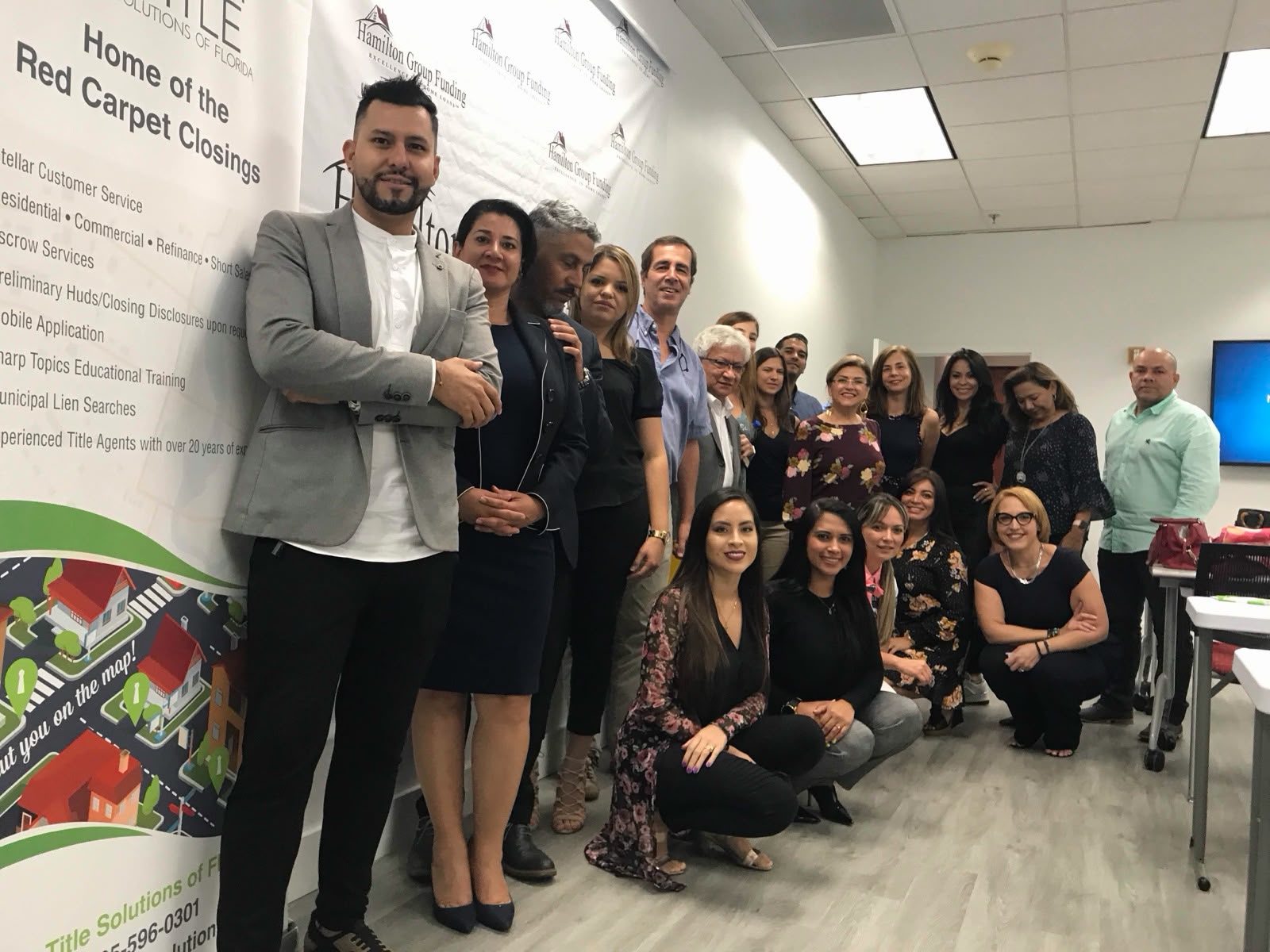 Grupo de asistentes posando con Juliana en evento Hamilton Group Funding